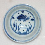 Kleine Ming Dy Schale Blau-Weiss mit Fisch und Wasserpflanzen im Zentrum sowie an der Aussenwandung. Boden unglasiert.
