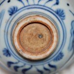 Kleine Ming Dy Schale Blau-Weiss mit Fisch und Wasserpflanzen im Zentrum sowie an der Aussenwandung. Boden unglasiert.